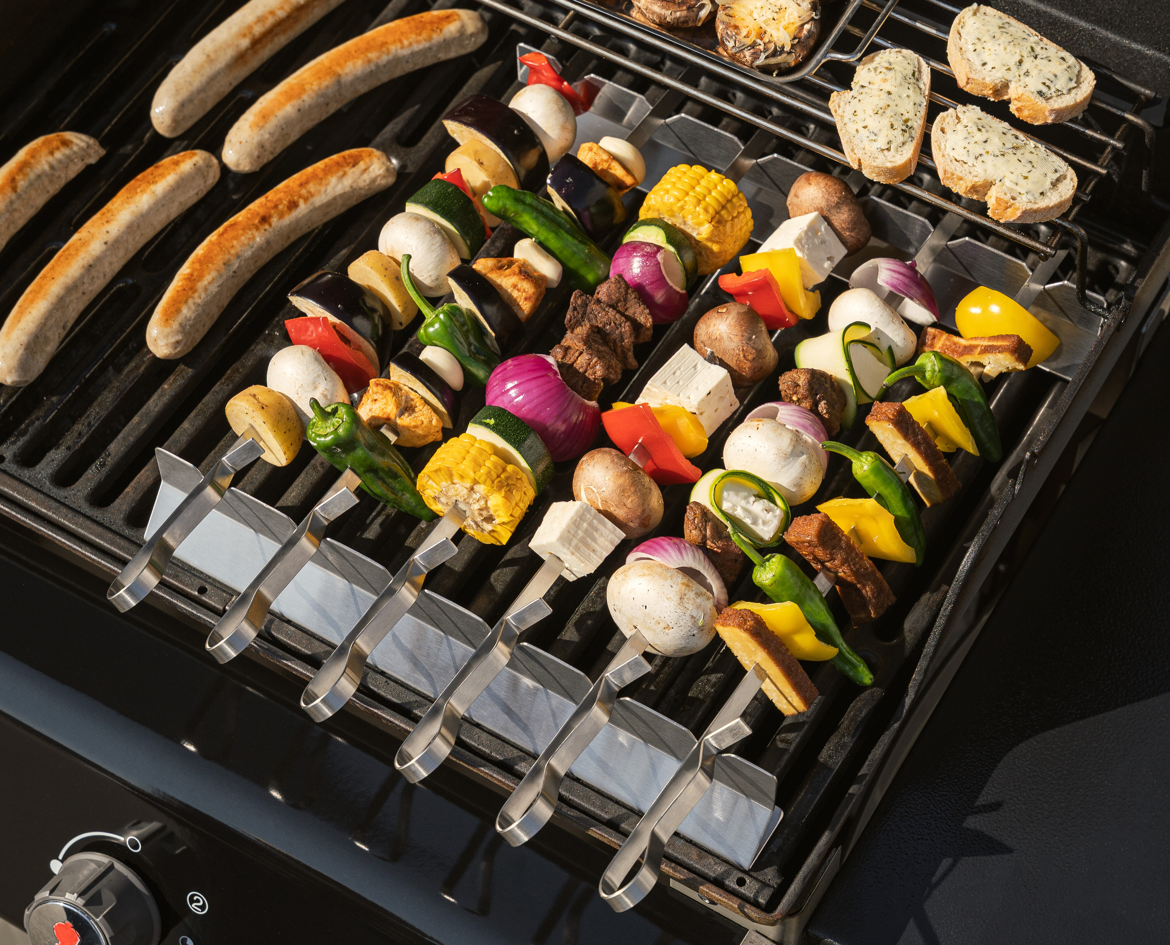 Ein Grill, auf dem verschiedene Spieße wie Fleisch und Gemüse zubereitet werden