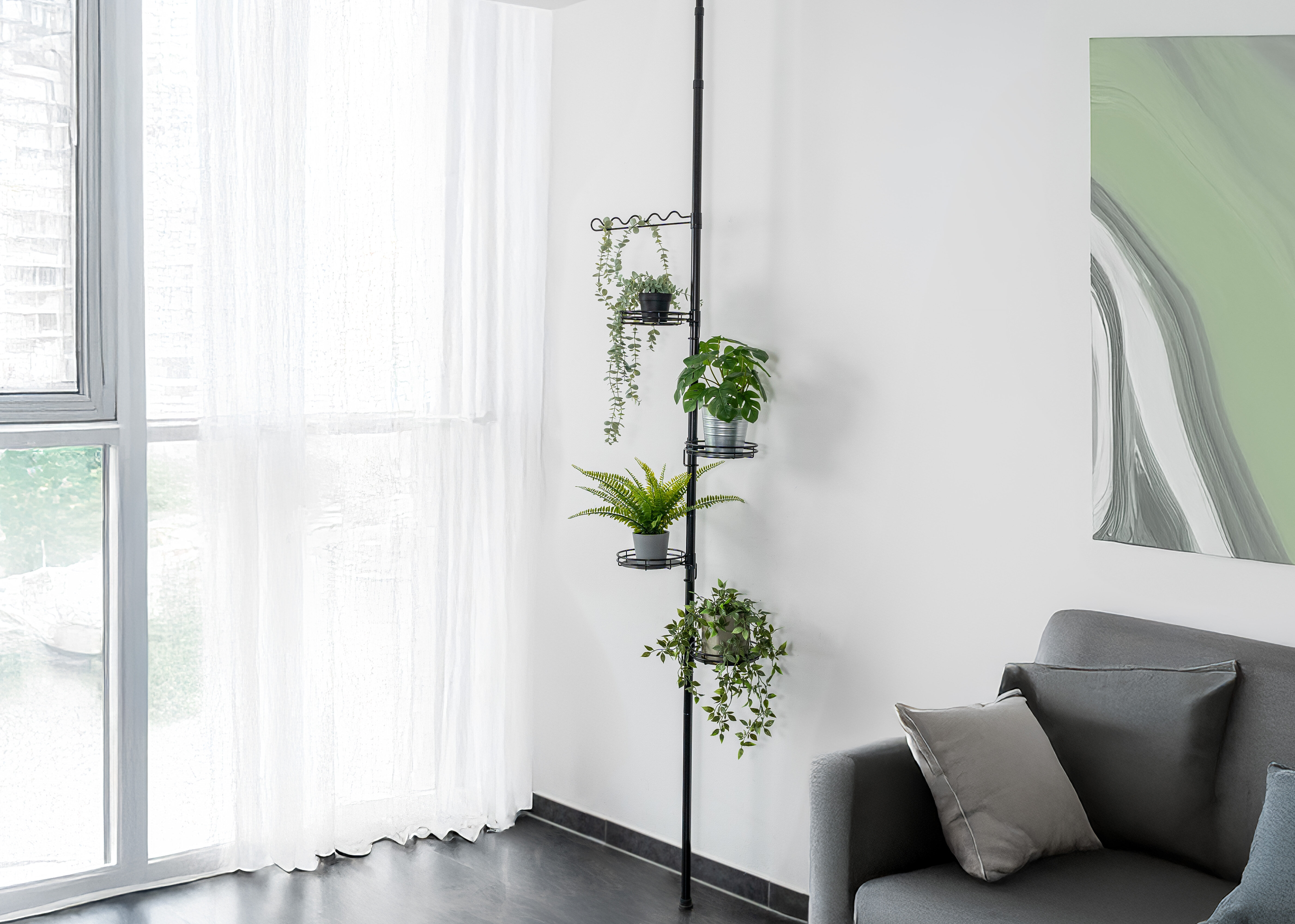 Ein Wohnzimmer mit einem Sofa, Pflanzen auf einem Teleskopregal und einem Fenster, das Tageslicht hereinlässt.