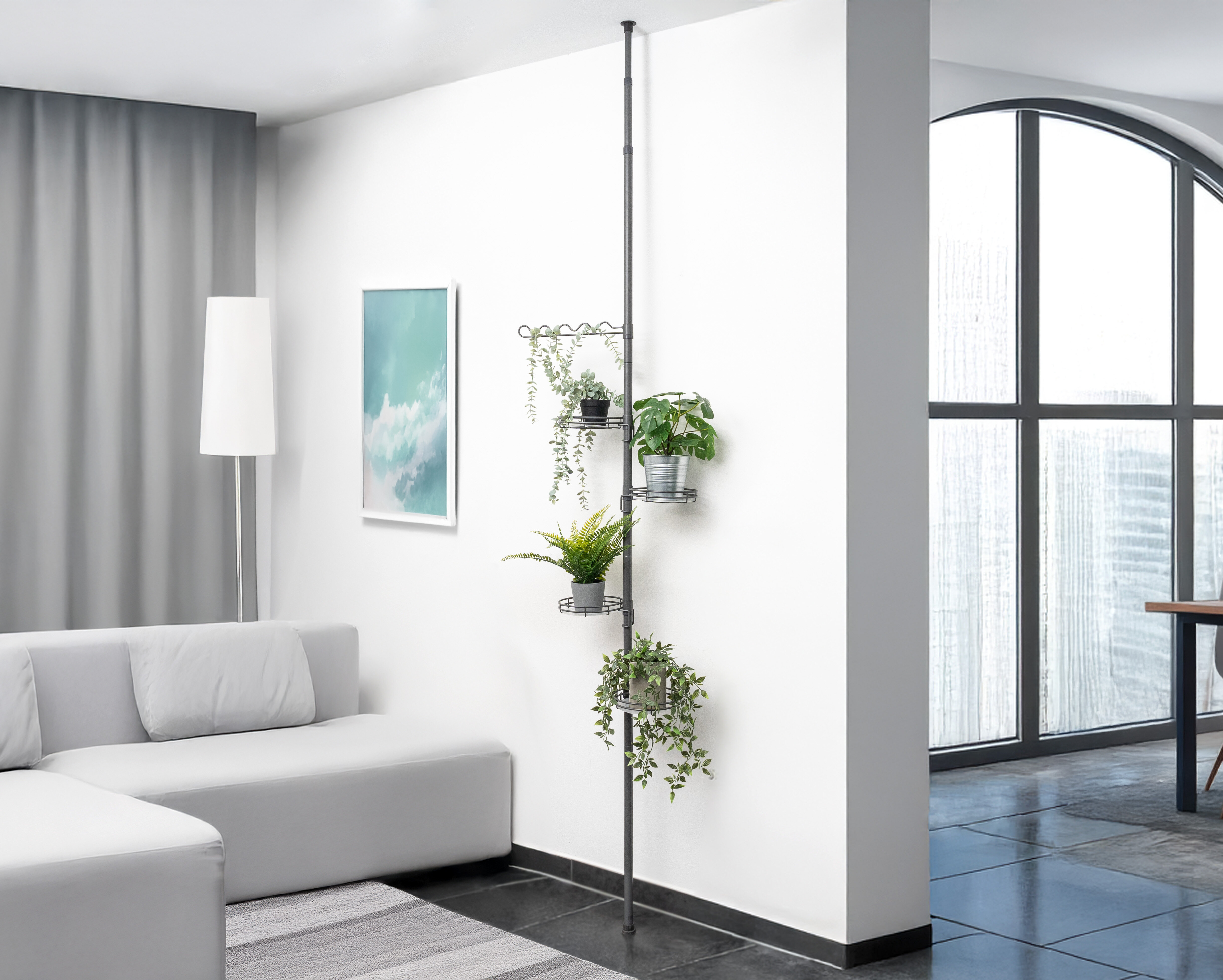 Ein helles Wohnzimmer mit Pflanzen auf einem grauen Teleskopblumenregal auf unterschiedlichen Höhen und einem hellen Sofa.
